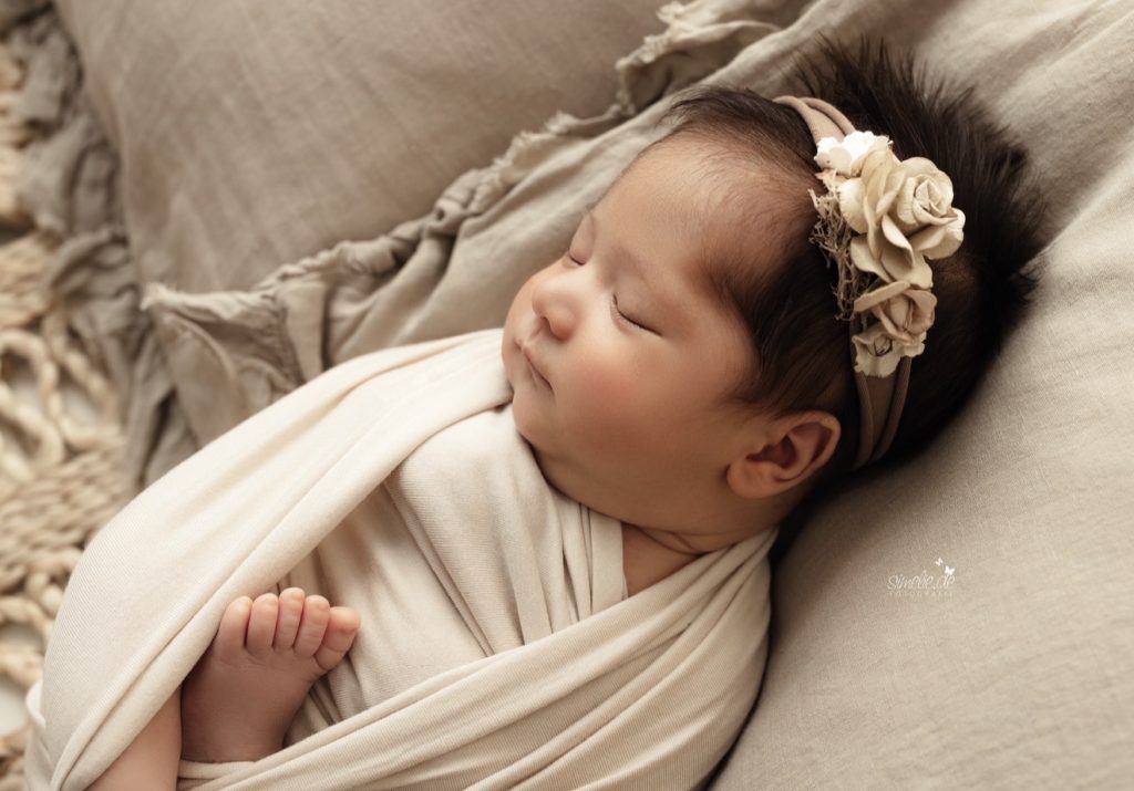 Schlafendes Baby mit floralem Haarband